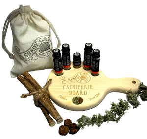 Shady Cat Co. catnip products including a wooden board, bags, and catnip sticks on a gray background.